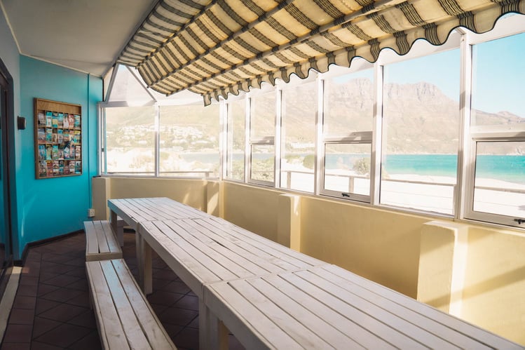 AIFS-freiwilligenarbeit-Südafrika-hout-bay-backpacker-lodge-unterkunft-wintergarten-essbereich