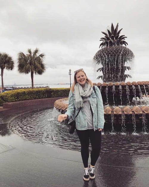 AIFS Au Pair in den USA steht vor einem Brunnen
