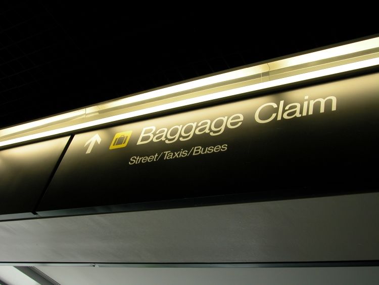 Schilder in Richtung Baggage Claim am Flughafen