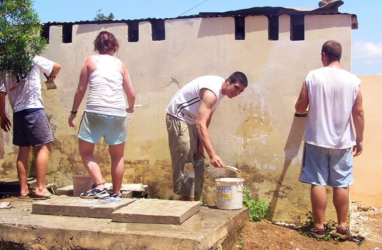 Personen streichen eine Wand beim Renovation & Construction Freiwilligenprojekt in Ghana mit AIFS