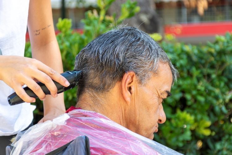 Volunteer beim Haare schneiden beim Freiwilligenprojekt Homeless Support in Griechenland mit AIFS