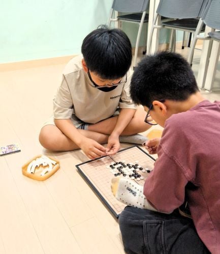 Kinder spielen ein Brettspiel beim Freiwilligenprojekt Childcare in Südkorea mit AIFS