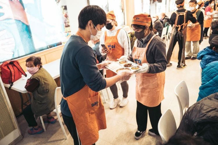 Volunteers verteilen Essen beim Freiwilligenprojekt Soup Kitchen in Südkorea