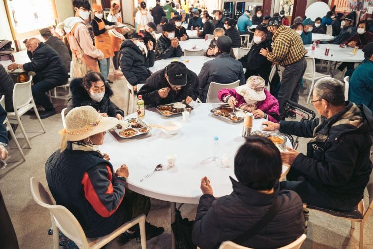 Menschen essen beim Freiwilligenprojekt Soup Kitchen in Südkorea