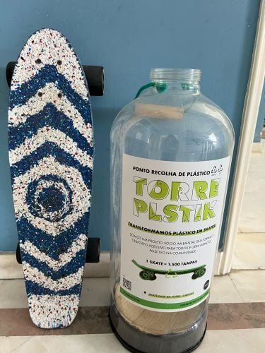 Ein Skateboard mit Muster und daneben eine Plastikflasche