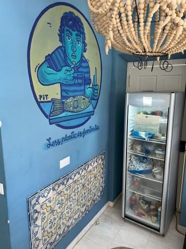 Kuechenbereich mit Kuehlschrank und einem Wandgemaelde