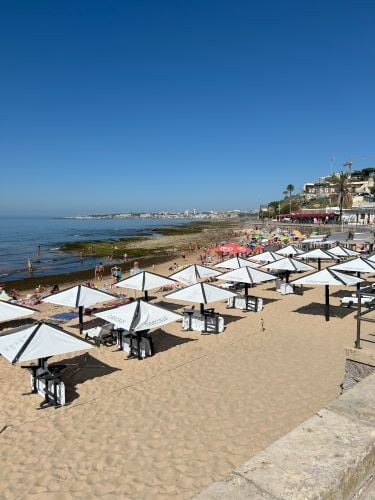 Ein Strand mit Schirmen und Liegen in Portugal