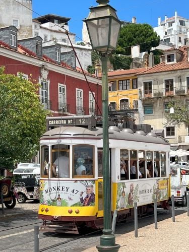 Eine Tram in der Innenstadt von Portugal drumherum sind mehrere Autos