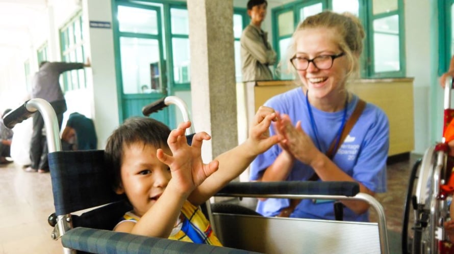 Ein Kind im Rollstuhl und eine Teilnehmende beim Medical Freiwilligenprojekt in Vietnam