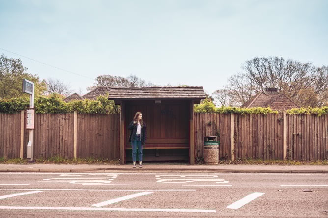 Austauschschülerin an einer Bushaltestelle in England