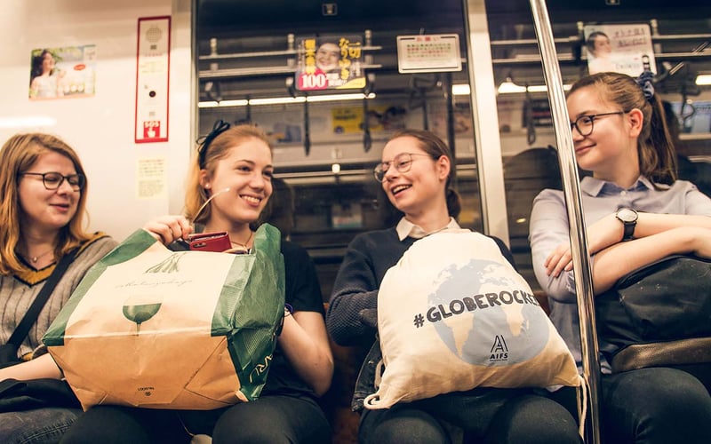 Stilvolle Tokyo-Erkundung: Menschen in der U-Bahn, umgeben von der pulsierenden Energie der Stadt bei Nacht, erleben ein unvergessliches Abenteuer mit AIFS.