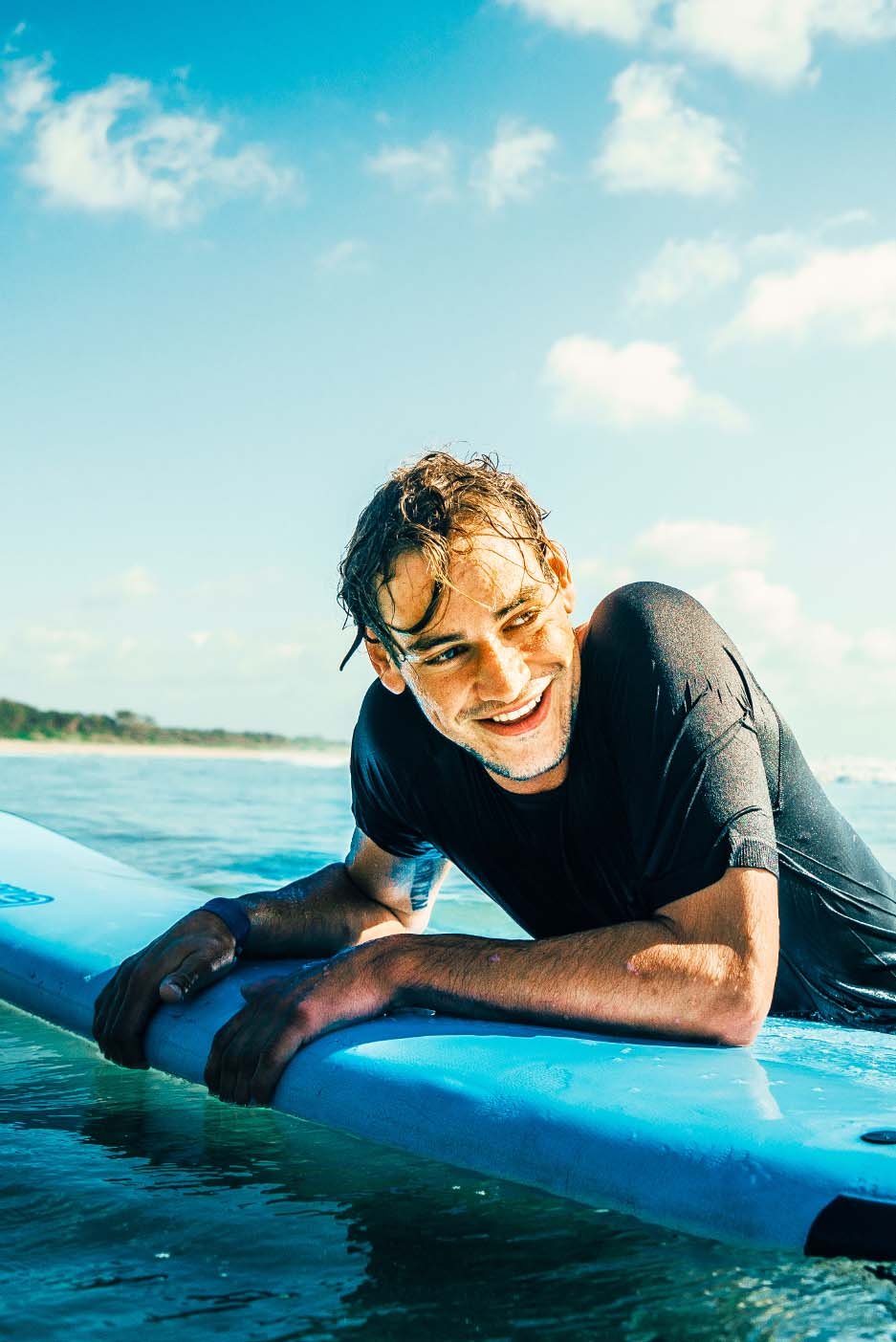 Junge Person mit Surfbrett am Meer im AIFS Surfcamp: Ein unvergessliches Erlebnis im Surfer-Programm.