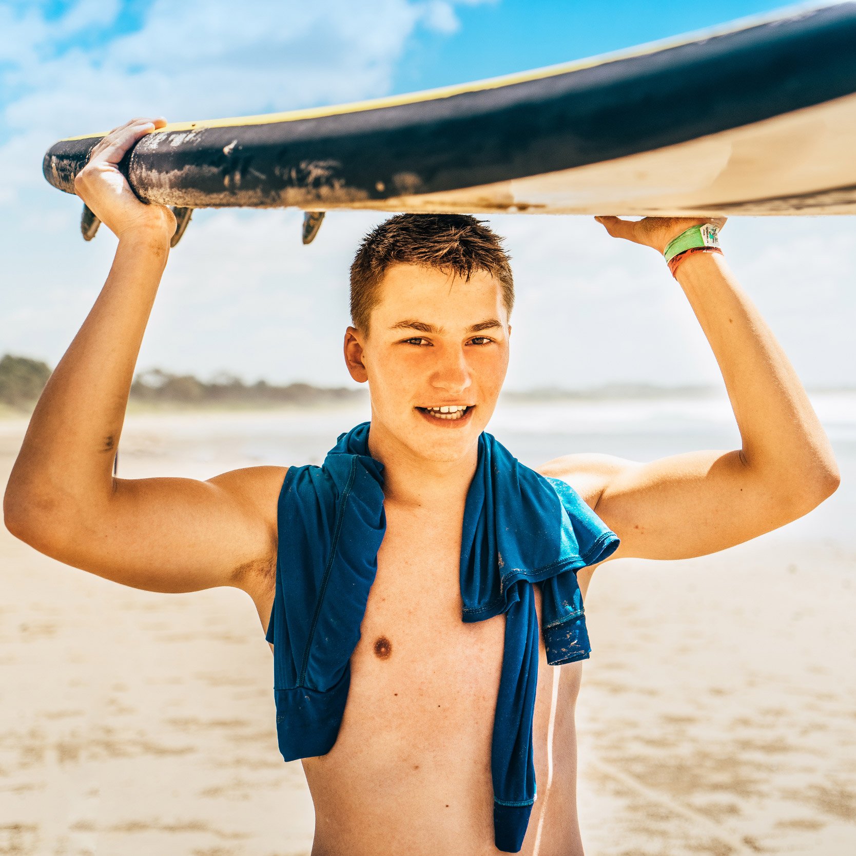 AIFS Surfcamp Australien: Ein Surfer mit Surfbrett am Meer erlebt unvergessliche Abenteuer mit AIFS Educational Travel.