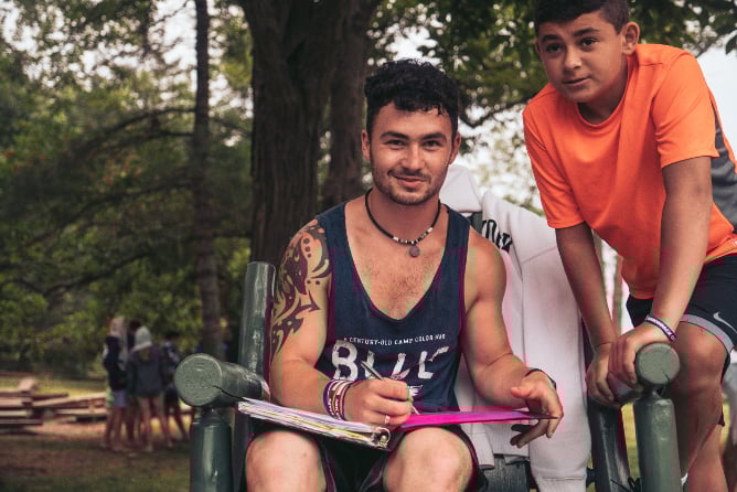 AIFS Camp America Betreuer mit Kind bei einer Aktivität im Sommercamp