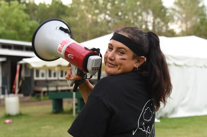 AIFS Teamer spricht mit den Camp America Teilnehmern über ein Megafon