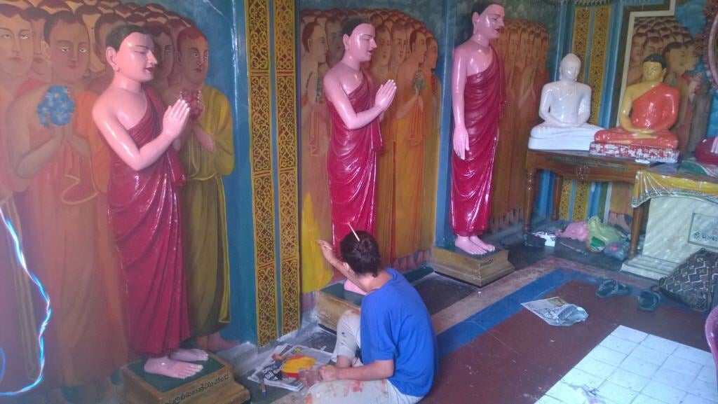 Freiwilliger in Sri Lanka streicht eine Statue im Renovation & Construction Projekt von AIFS.