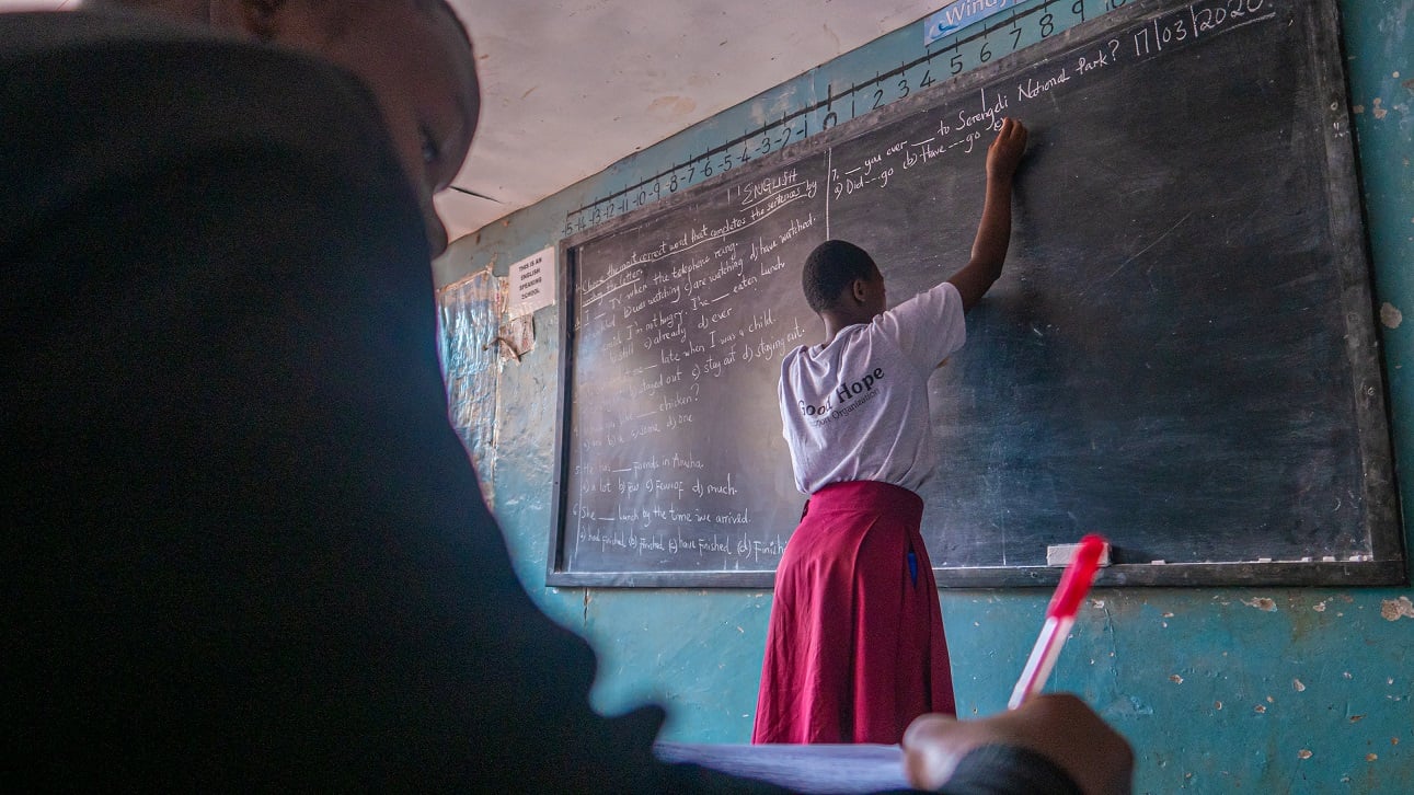 aifs-tansania-sansibar-freiwilligenarbeit-child-and-youth-care-personen-unterricht-tafel-klassenraum-lehrerin